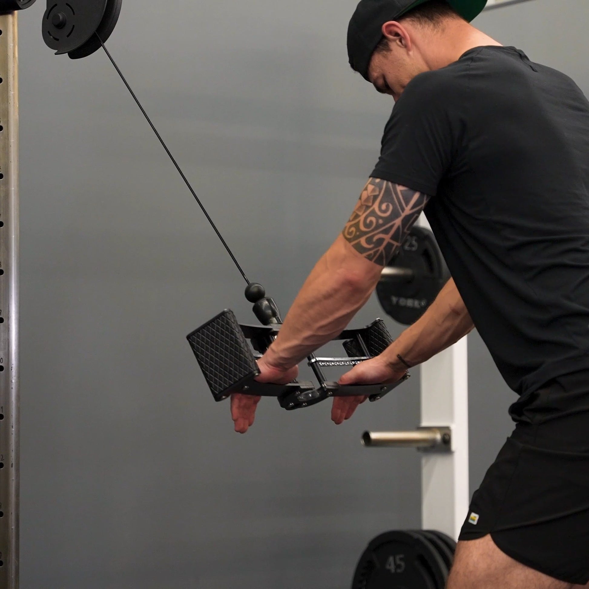 Lifter with both palms flat on the Back Bar's centre section at the bottom of a straight-arm pull