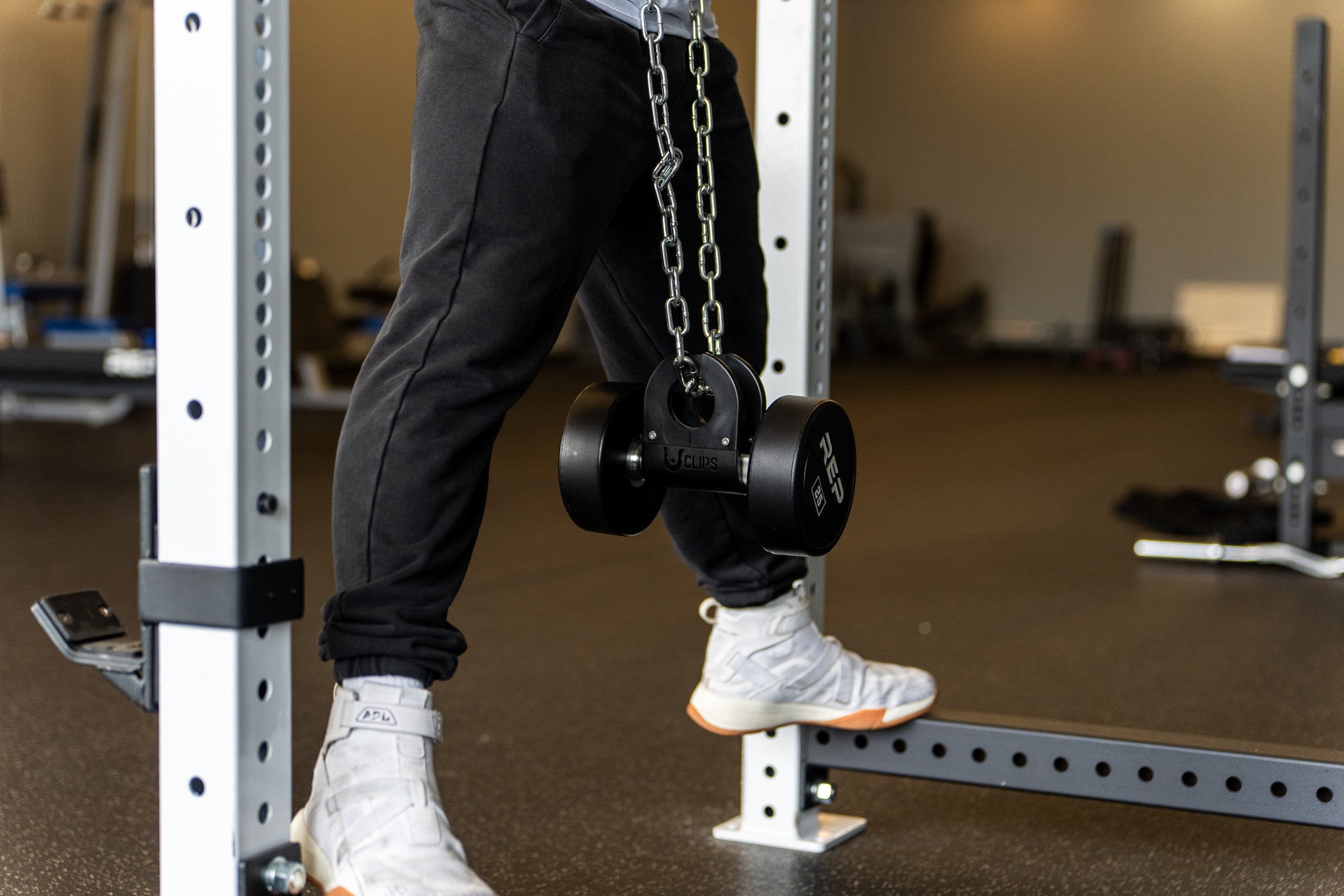 A dumbbell hung from a dip belt chain with a U Clip for weighted dips